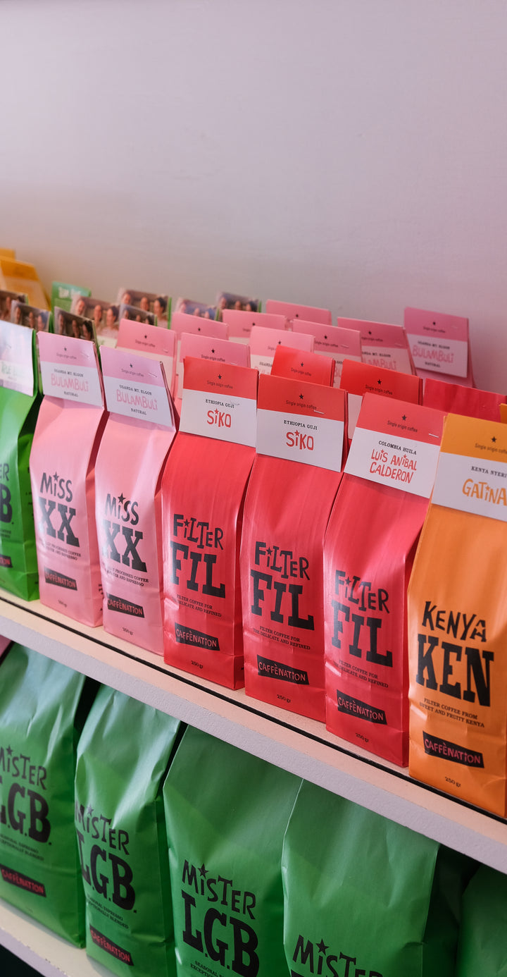 A shelf of Caffenation filter coffee bags in green, pink, red and orange
